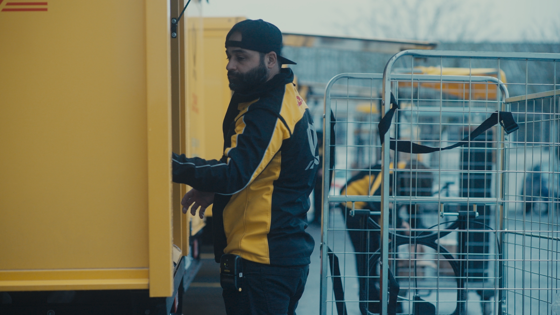 Ein männlicher Paketzusteller lädt Pakete auf einen LKW.