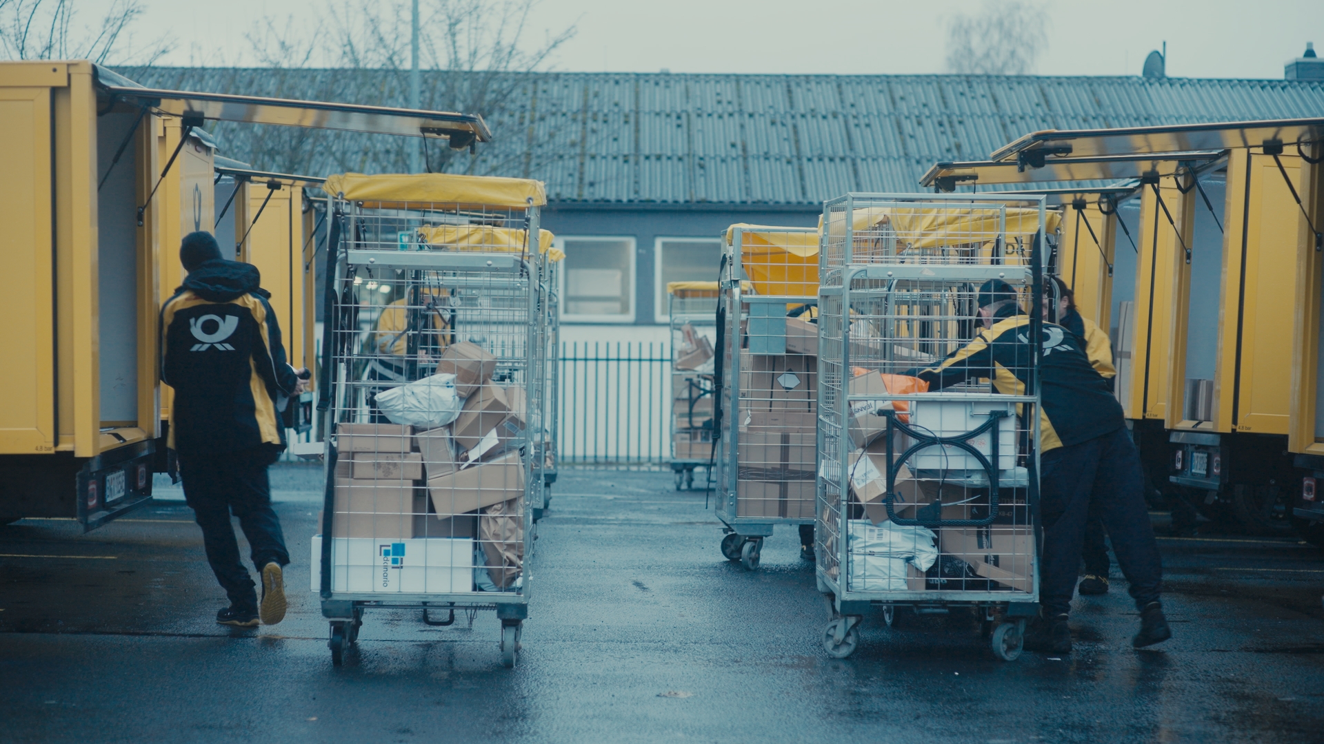 Zwei Personen laden Pakete in LKWs.