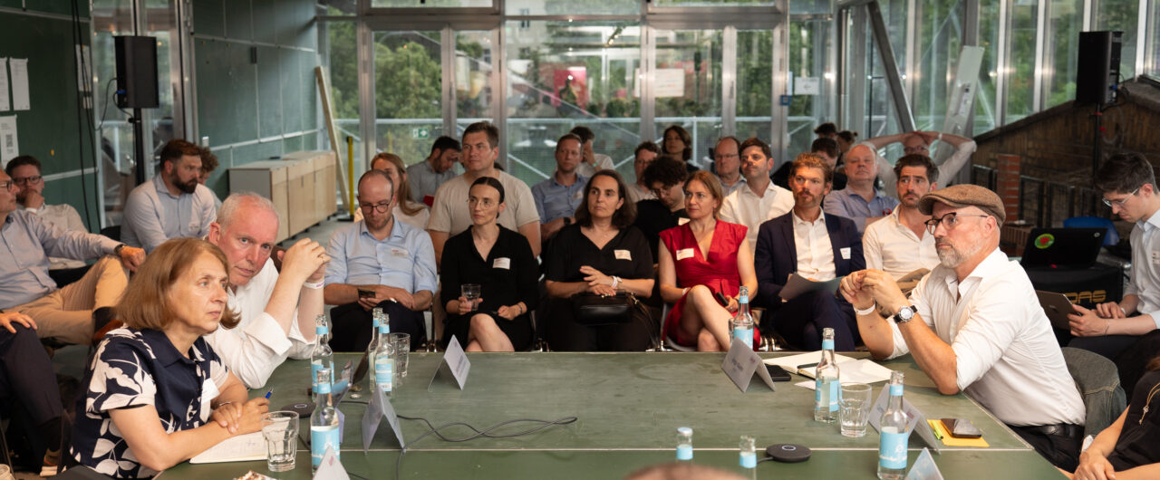 Konferenzsetting mit Round Table und Publikum